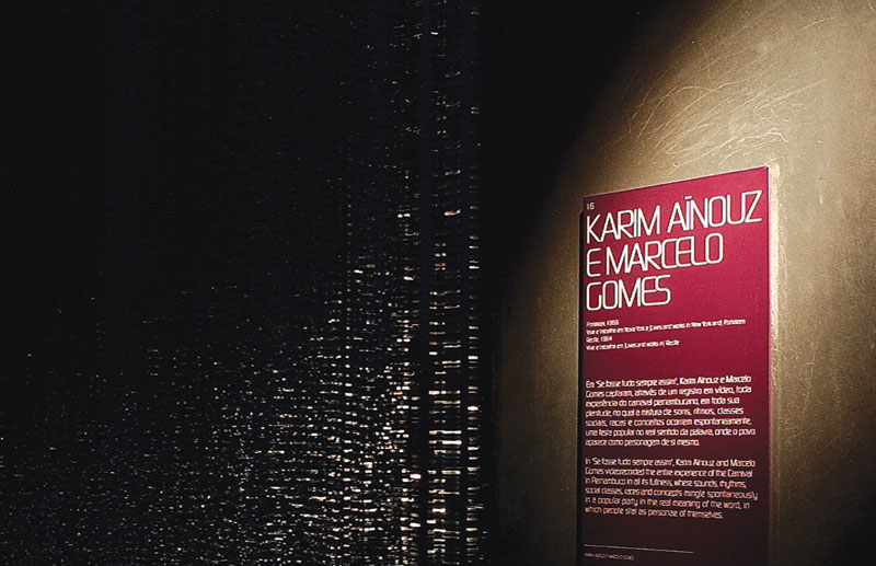 Painel de identificação de Karim Aïnouz e Marcelo Gomes na 26ª Bienal de São Paulo, aplicado junto à instalação audiovisual e integrado ao sistema gráfico da exposição.