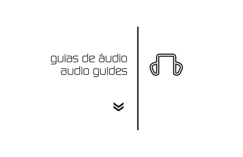 Sinalização bilíngue dos guias de áudio da 26ª Bienal de São Paulo, com tipografia, seta direcional e pictograma de fones de ouvido desenvolvidos para orientação dos visitantes.